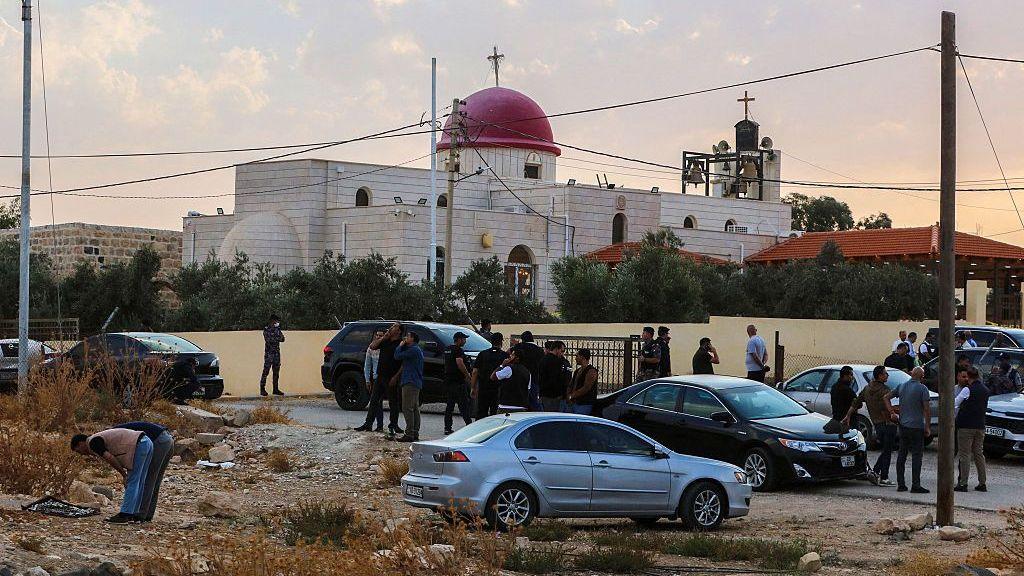 Image caption,Security officials and members of the public gathered outside the Greek Orthodox church on Friday