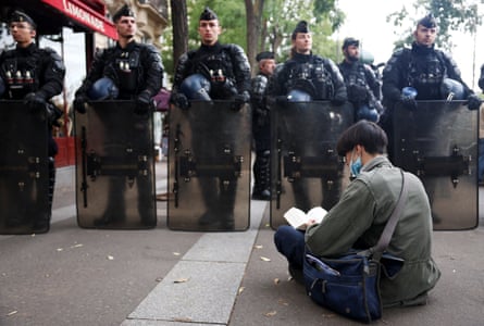 A demonstrator reads a book on the street at a protest organised by student collectives and trade unions in Paris on 22 October.Photograph: Abdul Saboor/Reuters
