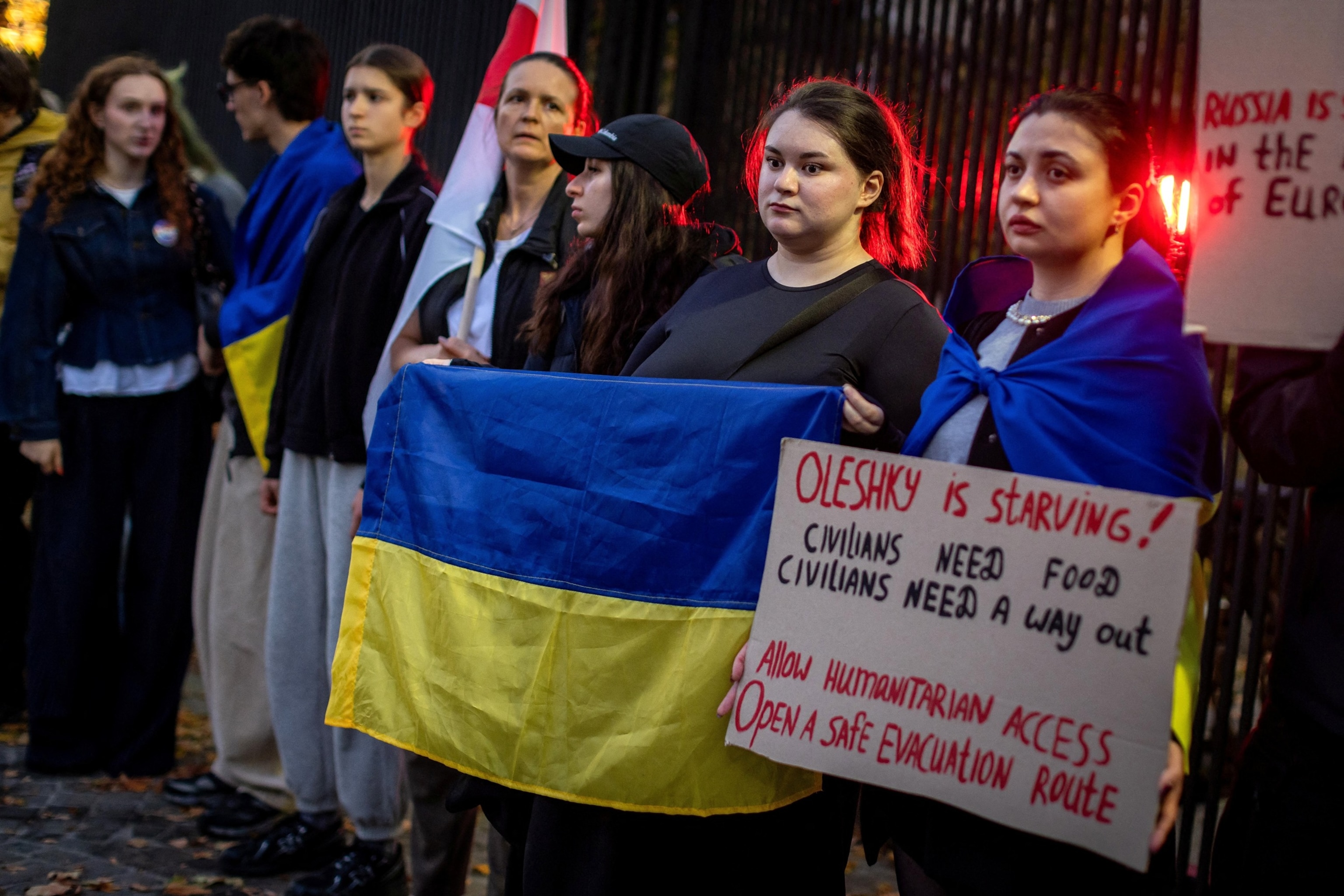 Members of the Ukrainian diaspora display a Ukrainian flag and a placard with the lettering 'Oleshky is starving' as they protest in front the US Embassy in Warsaw on Oct. 6, 2026, to demand international intervention to create a humanitarian corridor for the citizens of Oleshky, a town in Ukraine under siege by the Russians.Wojtek Radwanski/AFP via Getty Images, FILE