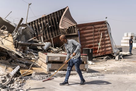 A Palestinian man clears debris outside a business demolished by Israeli forces in Hebron.Photograph: John Wessels/AFP/Getty