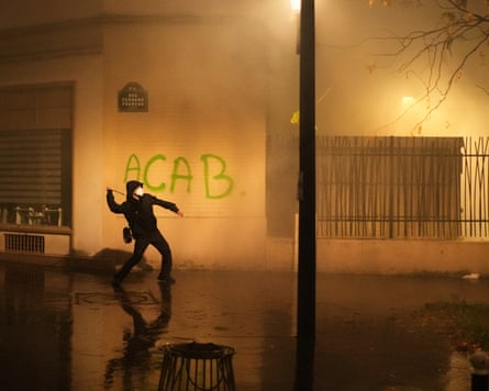 At the end of the Paris demonstration, different groups of masked men dressed in black emerged and threw glass bottles and stones at police.Photograph: Thibault Camus/AP