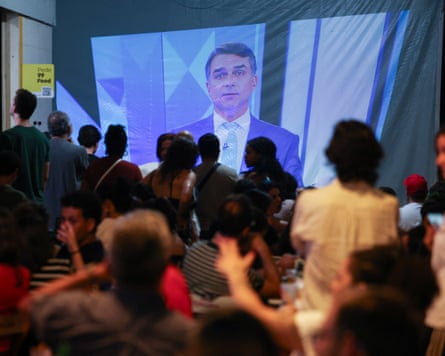 People watch a televised debate between Flávio Bolsonaro and his election rival on Friday.Photograph: Adriano Machado/Reuters