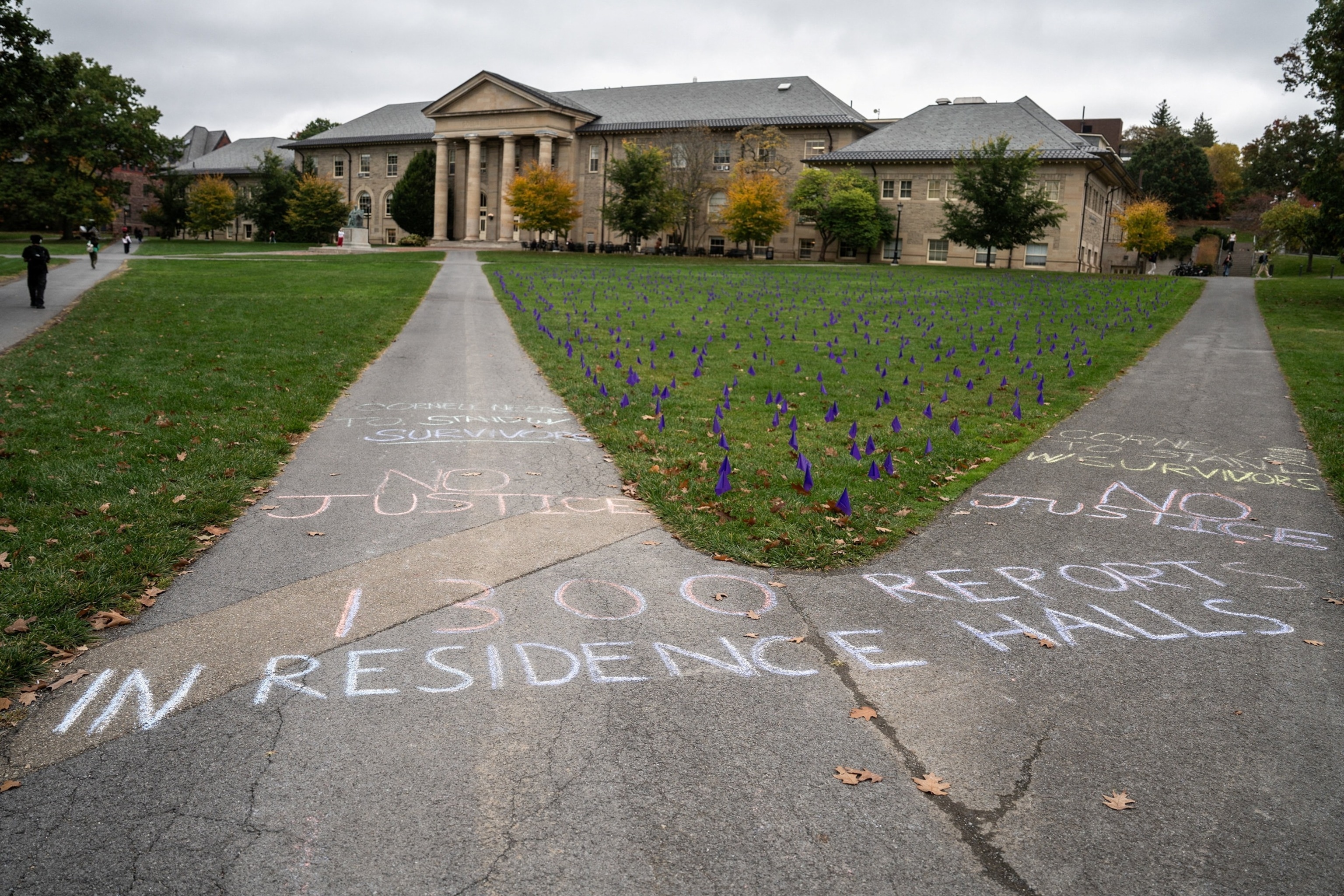 Chalk messages reading "1300 reports in residence halls" and "No Justice" are written on a sidewalk at the Ag Quad in Ithaca, New York, October 14, 2026.Matt Burkhartt/Reuters