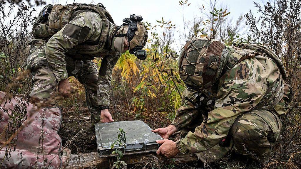 Image caption,Ukrainian soldiers set up a Starlink terminal on the battlefield