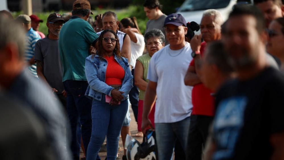 Image caption,Flavio Bolsonaro, accompanied by his wife, arrived at a polling station in Rio de Janeiro to cast his vote on Sunday morning