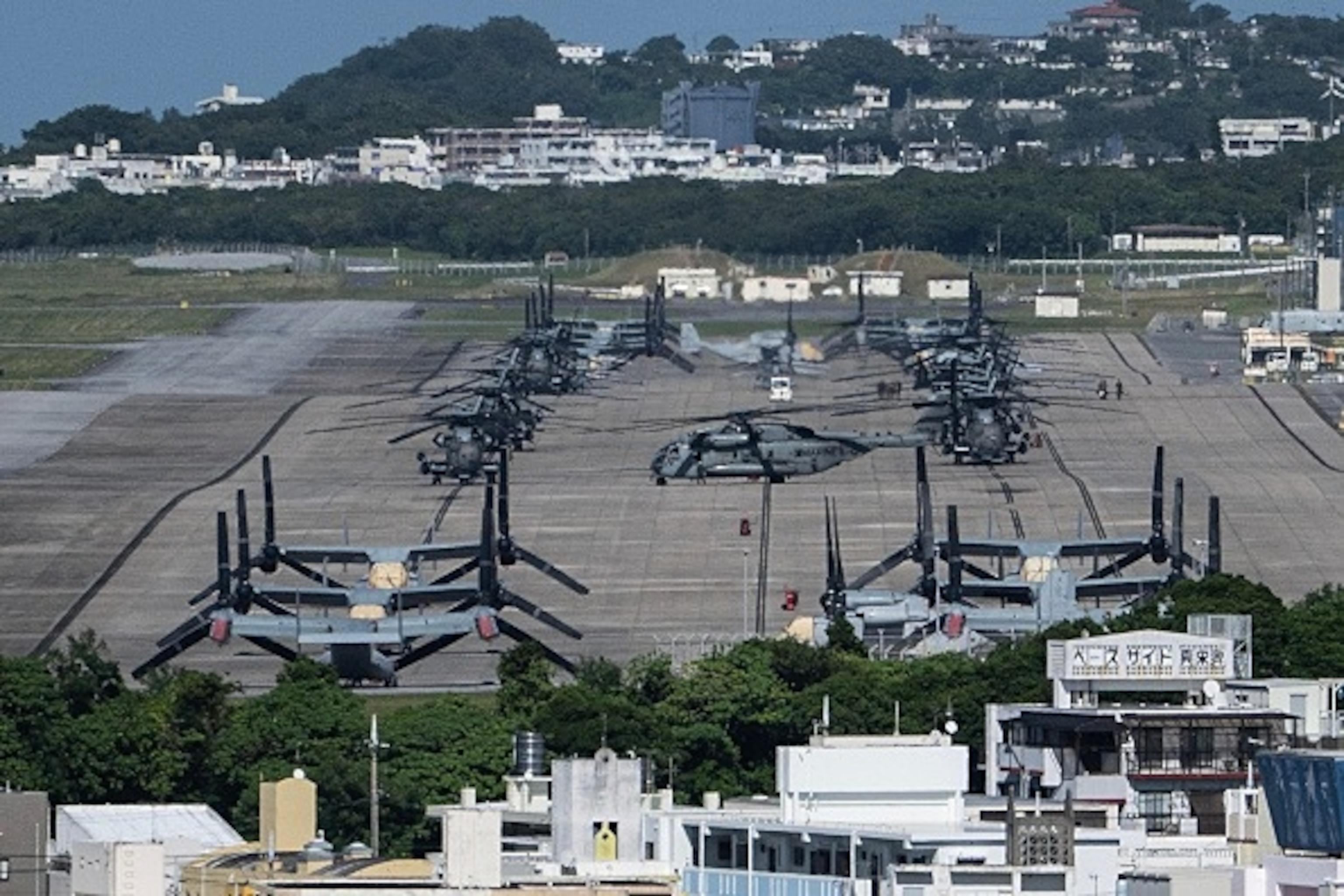 Helicopters and V-22 Ospreys are seen parked on the tarmac near buildings at Marine Corps Air Station Futenma in Ginowan, Okinawa prefecture, October 9, 2026. Lawmakers in Okinawa adopted a resolution on October 9 calling for revisions to a pact seen as giving the United States military preferential treatment in Japan, following a murder allegedly committed by an American Marine.Andrew Caballero-reynolds/AFP via Getty Images