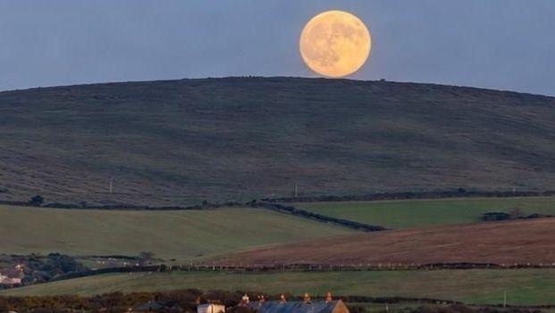 Image caption,A view of the moon from Kimmeridge in Dorset, UK