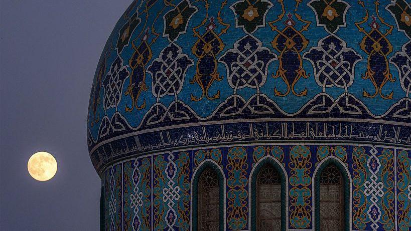 Image caption,Moonrise in Baghdad's Firdous Square, Iraq