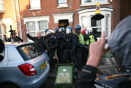 A person attempts to calm the crowd as police officers are attacked by demonstrators in Southampton.Photograph: Justin Tallis/AFP/Getty Images