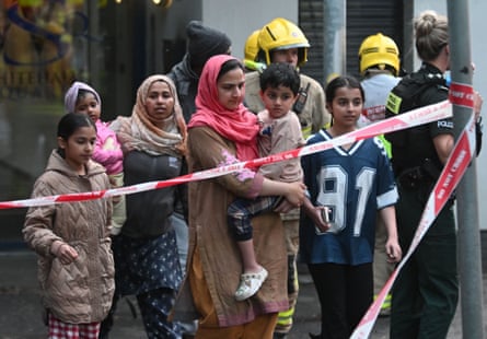Police evacuate families from their homes in south Belfast amid the riots.Photograph: Alan Lewis/Photopress Belfast