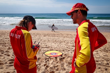 Lifesaver Oliver Heys advises fellow lifesaver – and sister – Eliza as they fly a drone on Dee Why Beach in Sydney, Australia.Photograph: David Gray/AFP/Getty Images