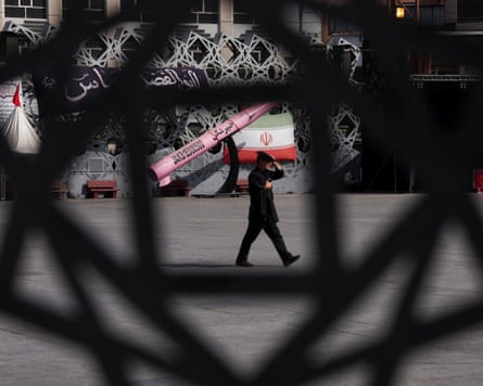 A man walks past a mockup of an Iranian missile and flag in Tehran.Photograph: Majid Asgaripour/West Asia News Agency/Reuters