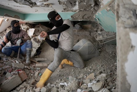 Volunteers use hammers in search operations in the rubble of OPPE 25.