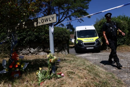A police officer walks past floral tributes left outside the home of Ann Widdecombe.Photograph: Jack Taylor/Reuters
