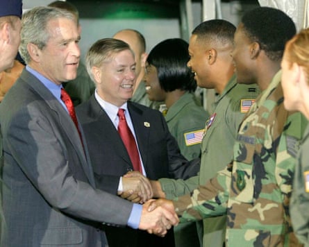 George Bush and Lindsey Graham greet military personnel at Charleston air force base in South Carolina on 24 July 2007, prior to watching a demonstration of cargo loading operation at the base.Photograph: Pablo Martínez Monsiváis/AP