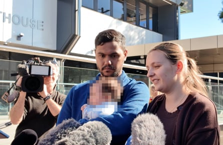 Armstrong’s sister Faith Isaacs outside court, with her partner cradling Armstrong’s baby.Photograph: Molly Glassey/The Guardian