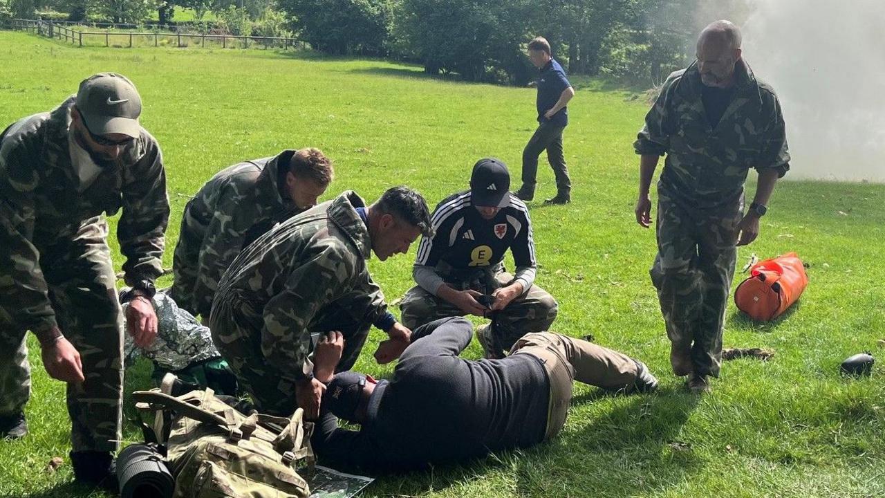 Image caption,Willy Caballero (left), Aaron Ramsey (second right) and Luke Williams (right) tend to a casualty as part of a course which counts Arsenal boss Mikel Arteta among its graduates