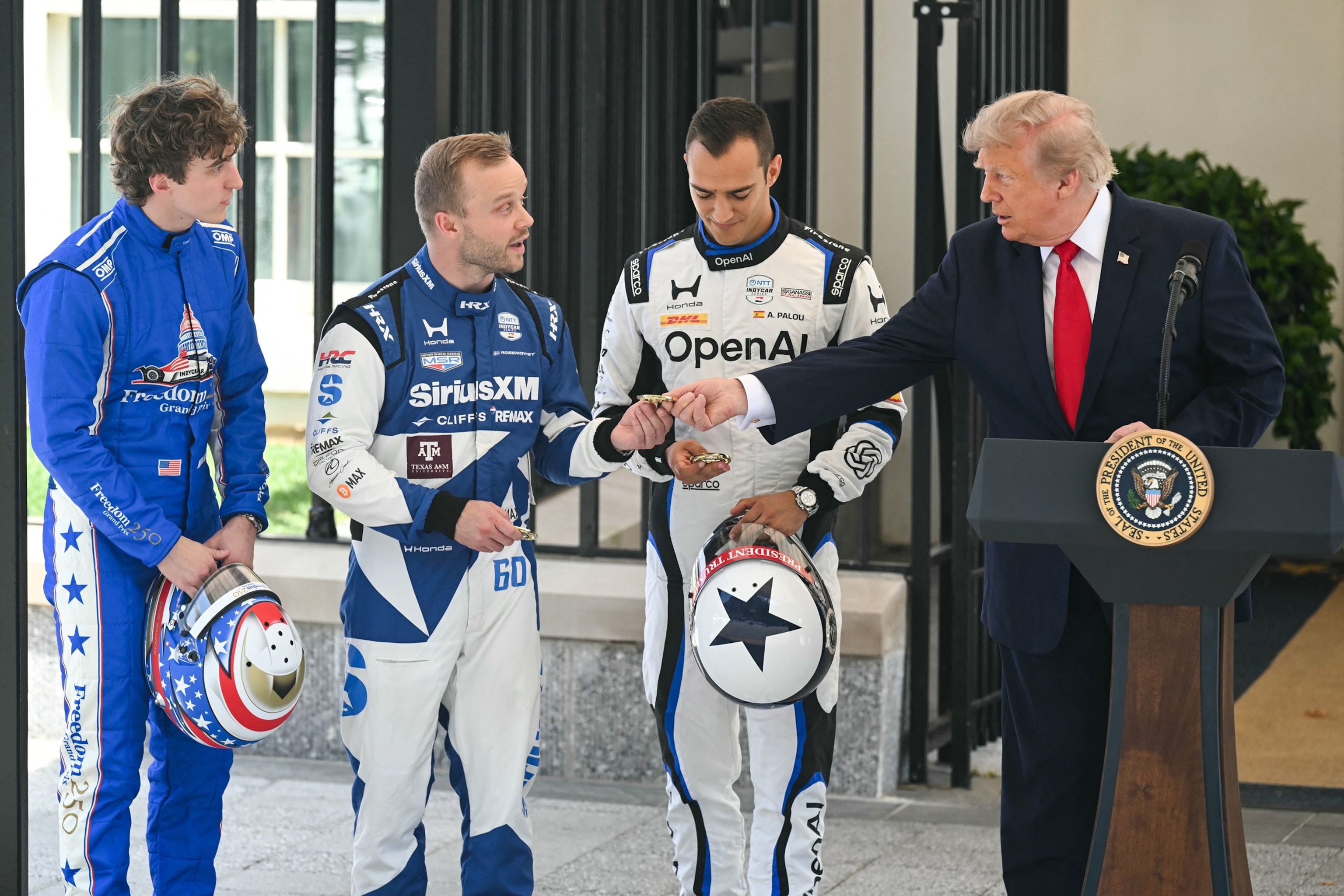 President Donald Trump speaks and gives challenge coins to IndyCar drivers David Malukas, Felix Rosenqvist, and Alex Palou during a Freedom 250 Grand Prix Showcase at the White House in Washington, July 13, 2026.Saul Loeb/AFP via Getty Images
