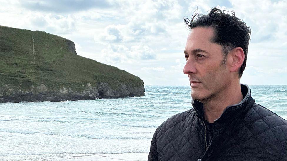 Image caption,Simon Andriesz, now living in Cornwall, has been in dispute with his former employers in the US for several years