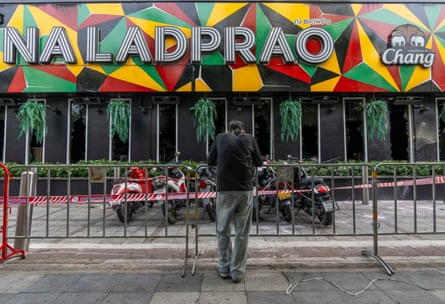 A mourner stands outside the Bangkok pub where dozens died in a fire on Monday.Photograph: Adryel Talamantes/Zuma Press Wire/Shutterstock