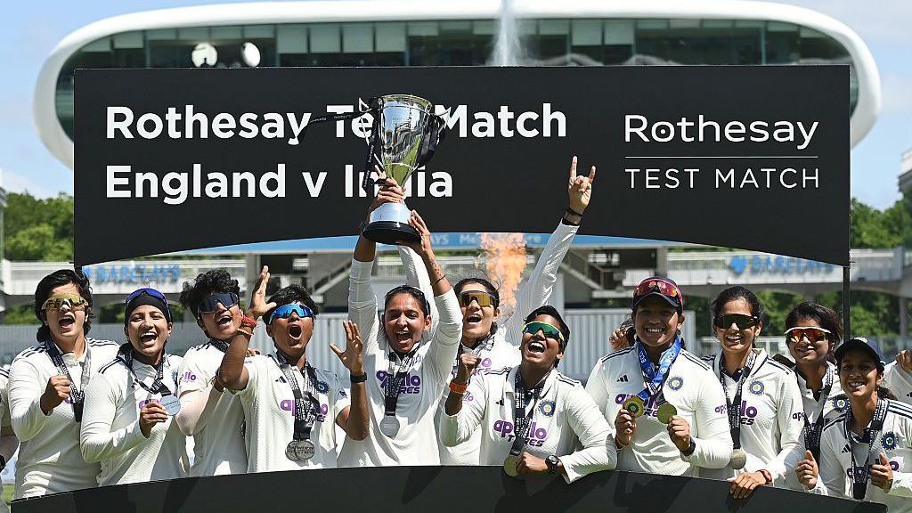 Image caption,India captain Harmanpreet Kaur holds the trophy up after India won the Test at Lord's