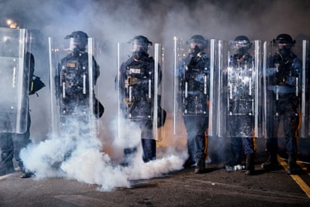 State police officers stand behind shields as tear gas fills the area outside the Delaney Hall detention center during a protest in Newark, New Jersey.Photograph: Andrés Kudacki/AP