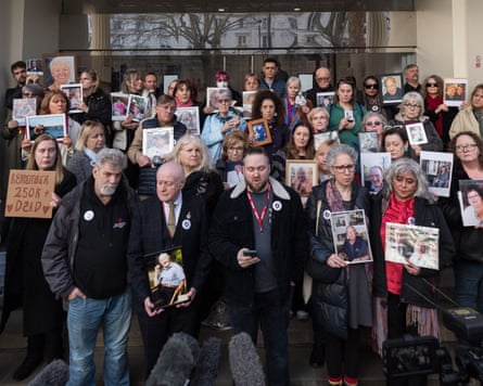 Members of the Covid-19 Bereaved Families for Justice group hold pictures of loved ones after the final hearings of the Covid inquiry in March.Photograph: Wiktor Szymanowicz/Zuma Press/Shutterstock