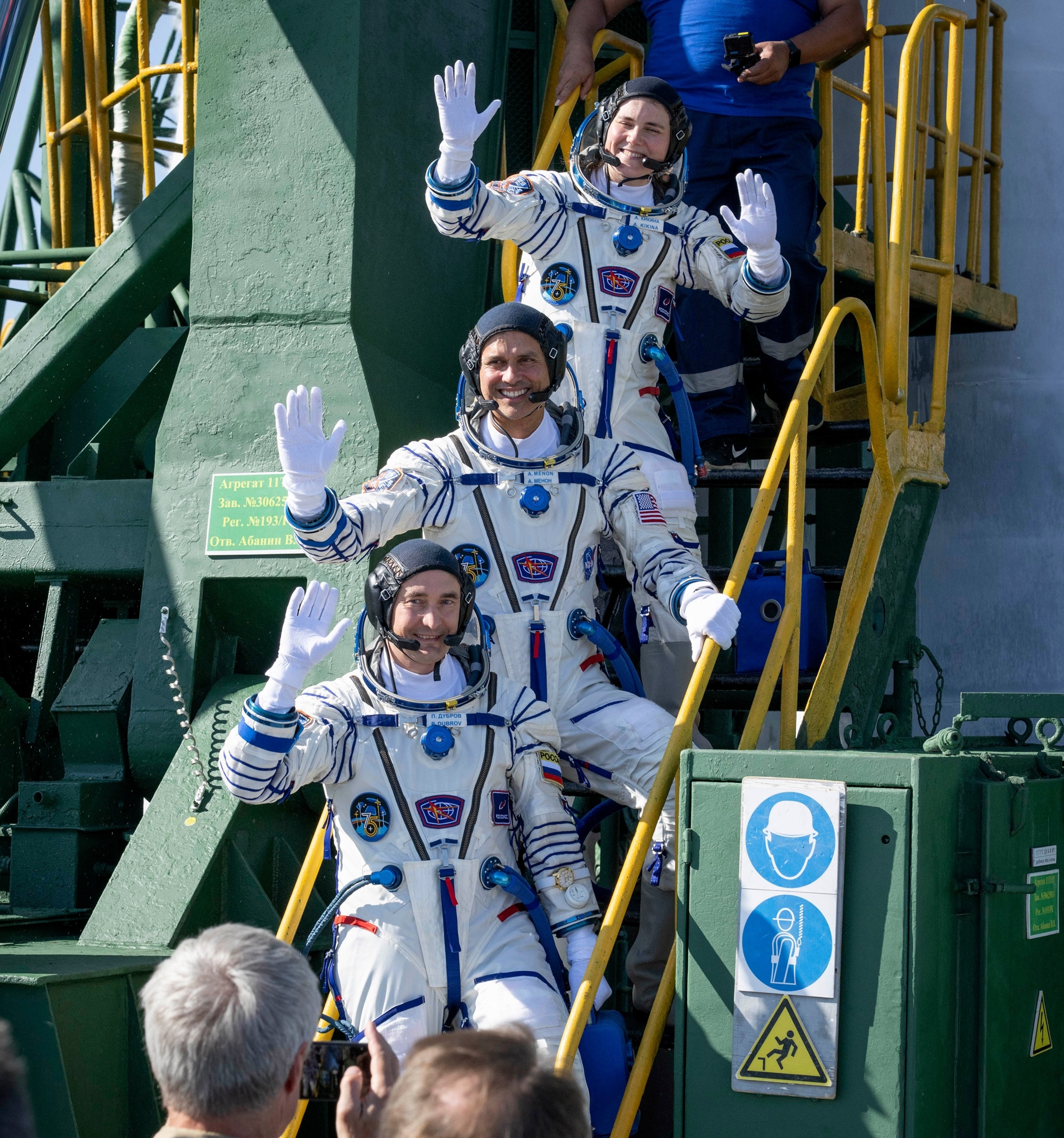 Expedition 75 Roscosmos cosmonaut Anna Kikina (top), NASA astronaut Anil Menon (C) and Roscosmos cosmonaut Pyotr Dubrov wave farewell prior to boarding the Soyuz MS-29 spacecraft for launch on July 14, 2026, at the Baikonur Cosmodrome in Baikonur, Kazakhstan.Bill Ingalls/NASA via Getty Images