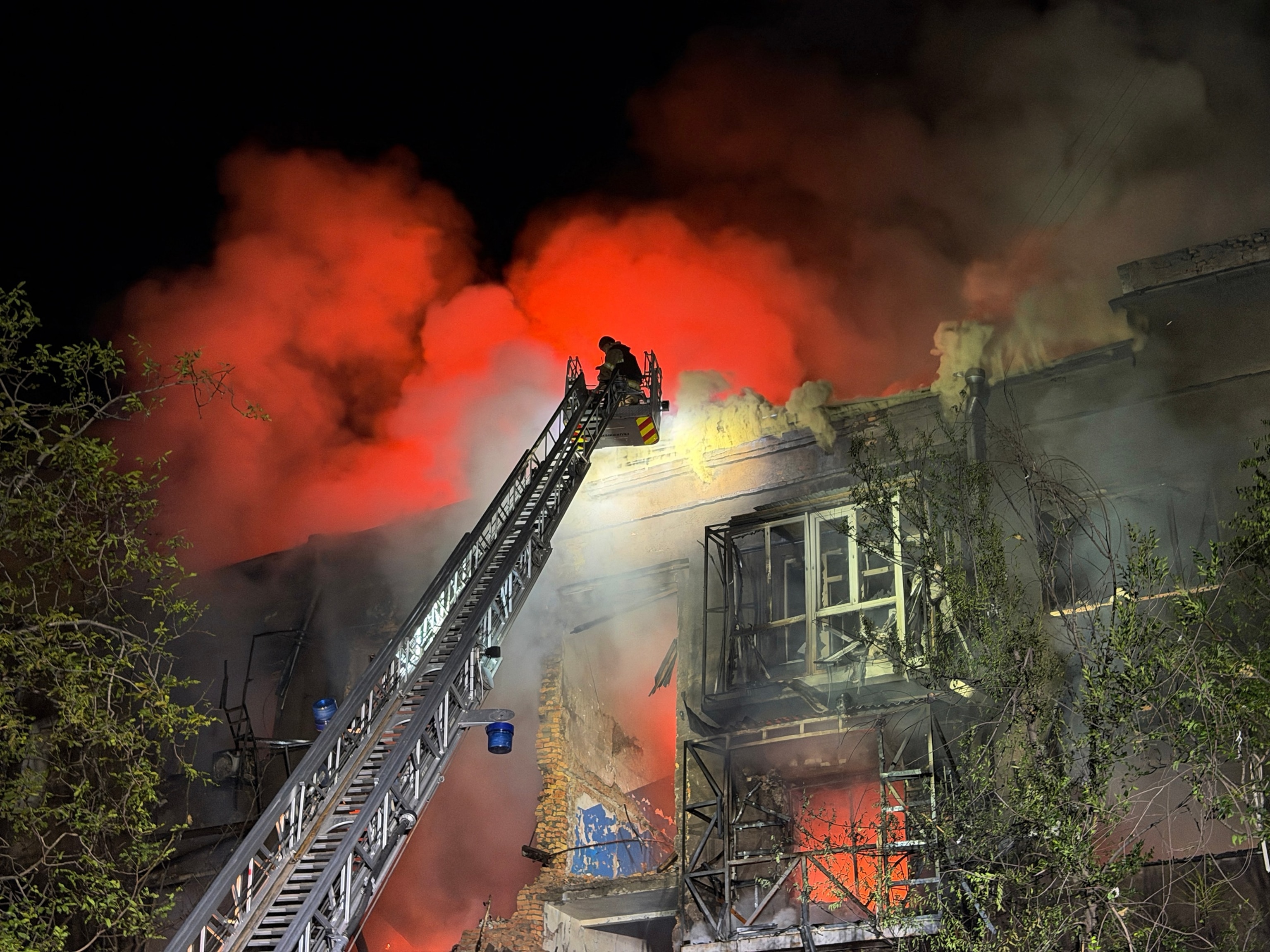 Ukrainian rescuers work to extinguish a fire at a damaged residential building following a Russian drone strike late night in Zaporizhzhia on July 12, 2026.Darya Nazarova/AFP via Getty Images