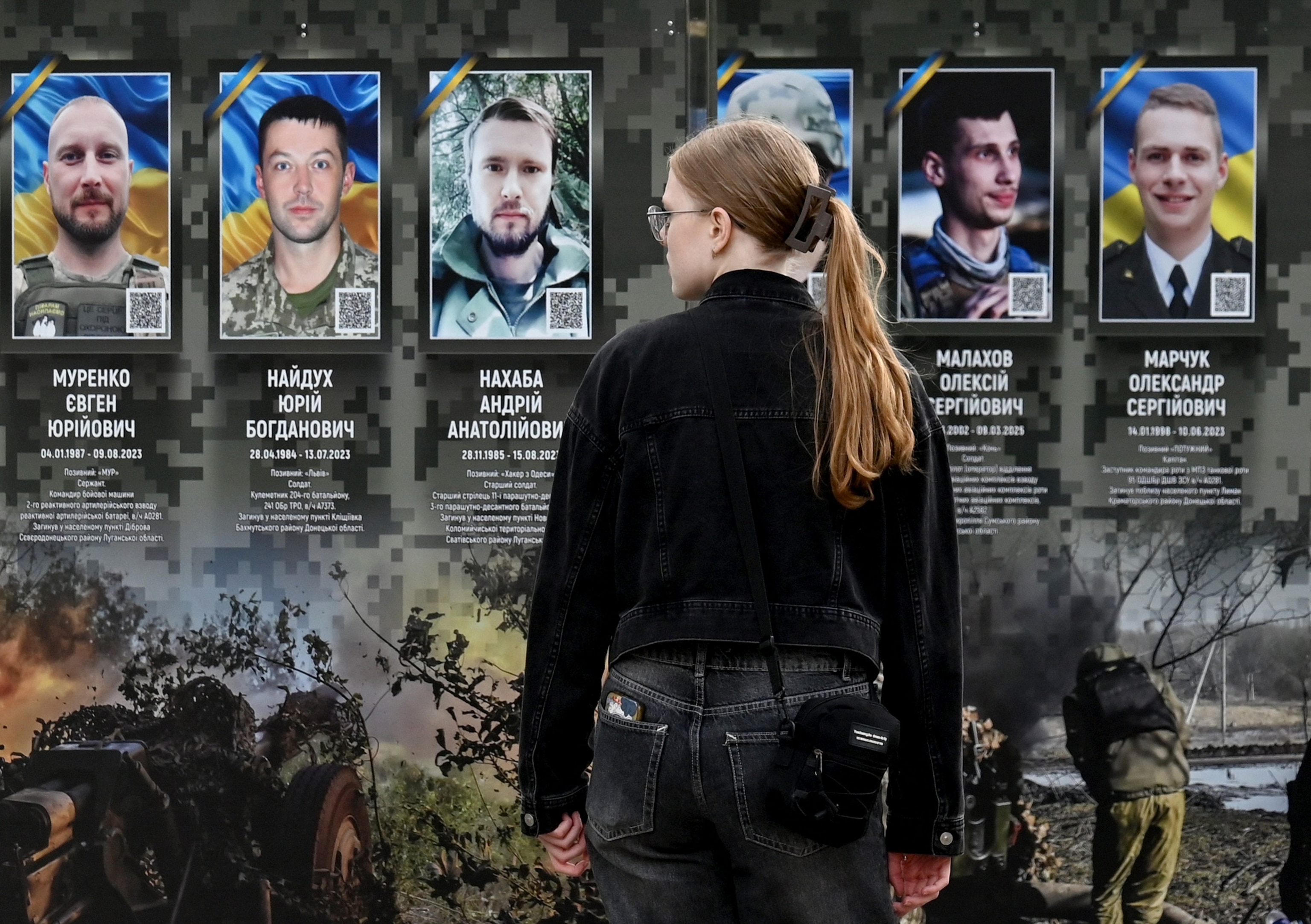 A woman looks at portraits at the Alley of Fallen Heroes in a district of Kyiv, Ukraine, on July 12, 2026.Sergei Supinsky/AFP via Getty Images