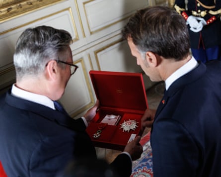 Starmer inspects his medal with Macron.Photograph: Simon Dawson/No 10 Downing Street