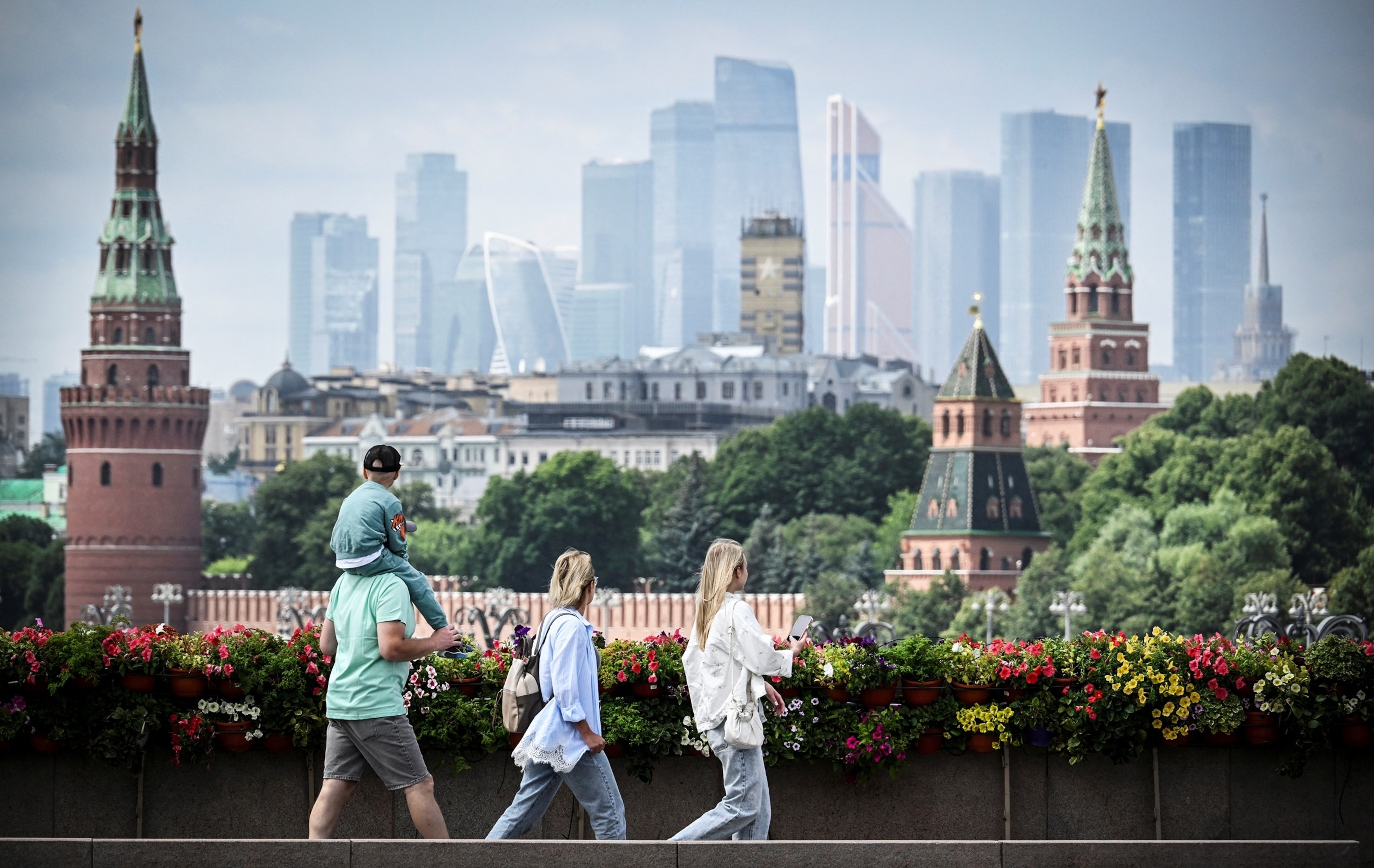 People walk on a bridge, with the Kremlin's towers and Moscow's International Business Centre in distance, in central Moscow on July 15, 2026.Alexander Nemenov/AFP via Getty Images