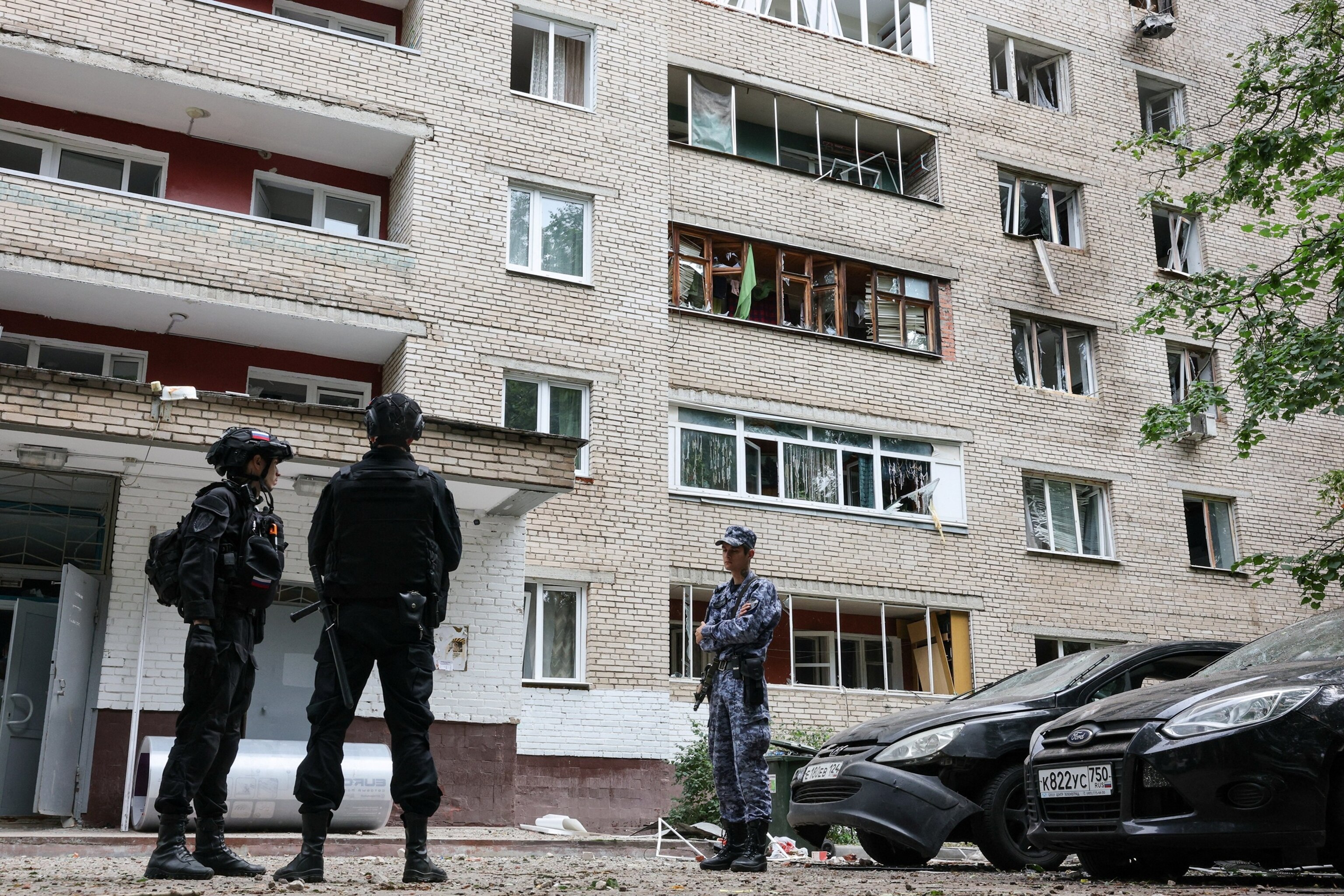 Law enforcement officers stand in front of a damaged an apartment building following a Ukrainian drone attack in the town of Solnechnogorsk, Moscow region, Russia, on July 13, 2026.Ramil Sitdikov/Reuters