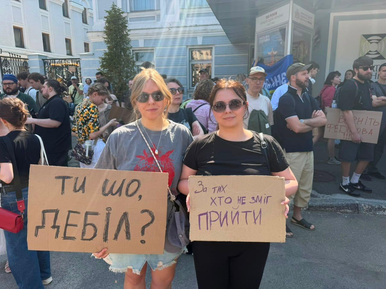 Image caption,Two young protesters against Fedorov's dismissal hold up signs reading "What are you doing, you idiot?" and "This is for all of those who couldn't be here"