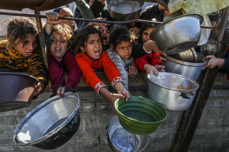 Palestinians wait to receive hot meals distributed by a charity in Khan Younis, Gaza, in January.Photograph: Anadolu/Getty Images