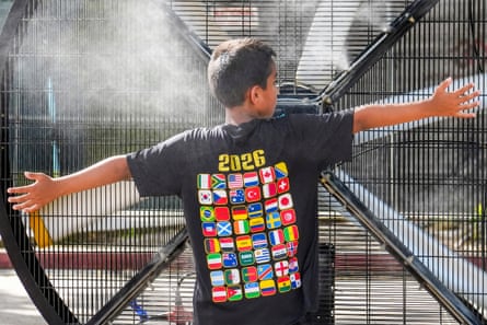 Young fan cooling off in a misting fan at the Dallas Fifa Fan Festival on 29 June 2026 in Dallas.Photograph: The Dallas Morning News/Hearst Newspapers/GettyImages