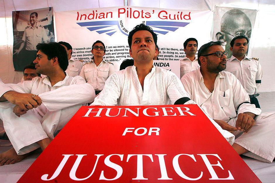 Image caption,Striking pilots hold placards during a hunger strike in Delhi in 2012