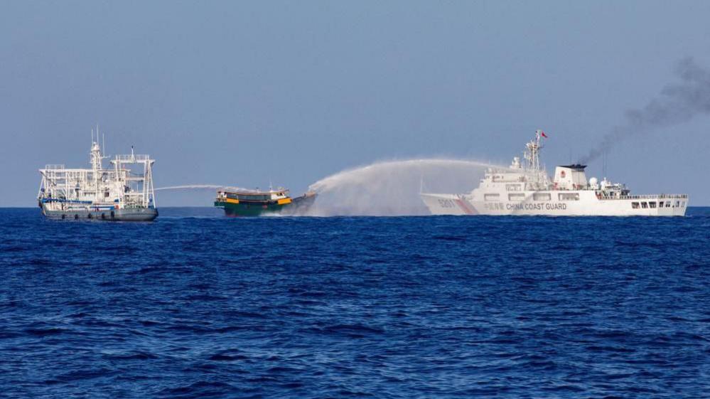 Image caption,An earlier photo of two Chinese Coast Guard vessels blasting water cannons at a Philippine boat