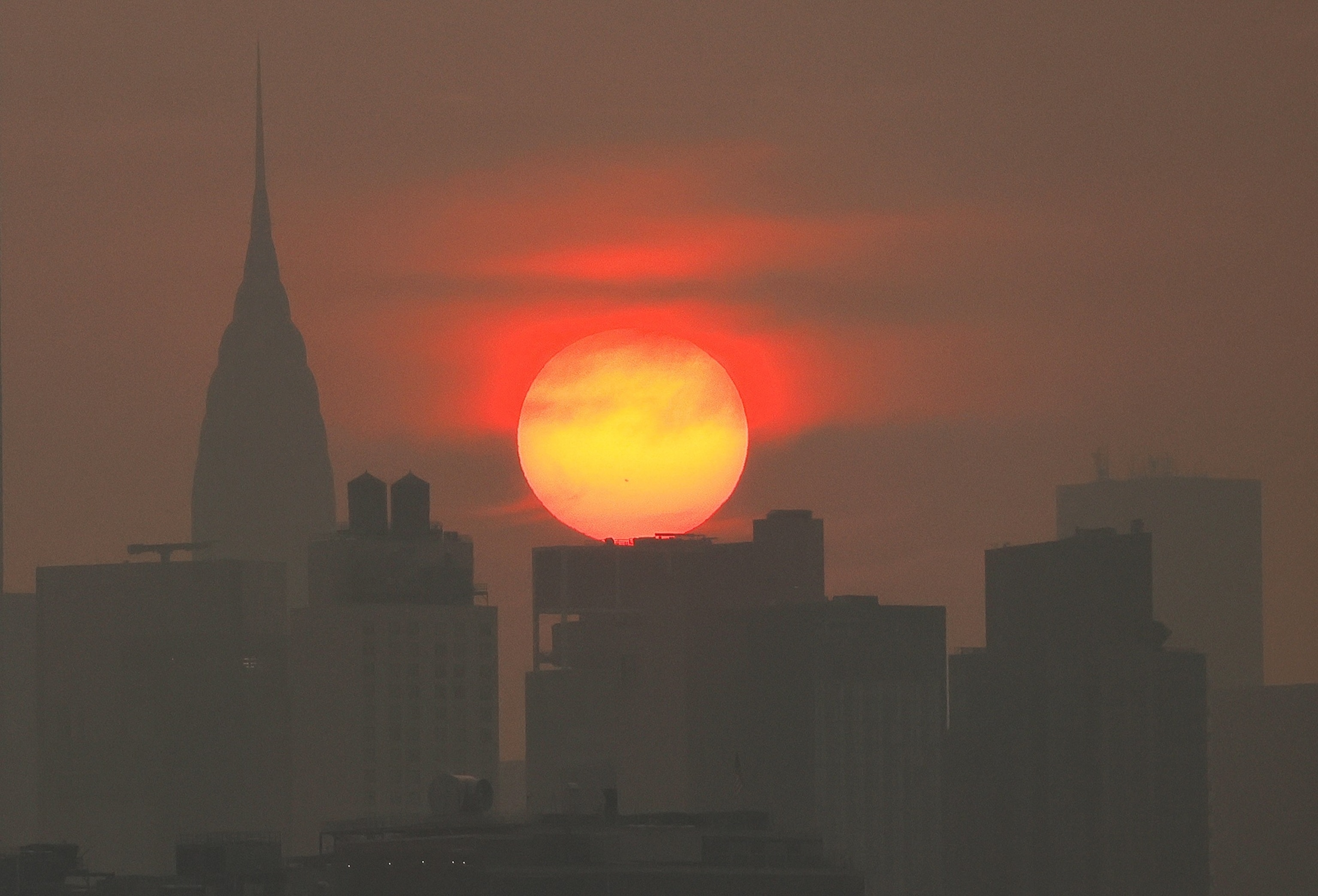 Wildfire smoke from Canada shrouds the sun as it rises behind the Chrysler Building in New York City, July 17, 2026.Gary Hershorn/ABC News