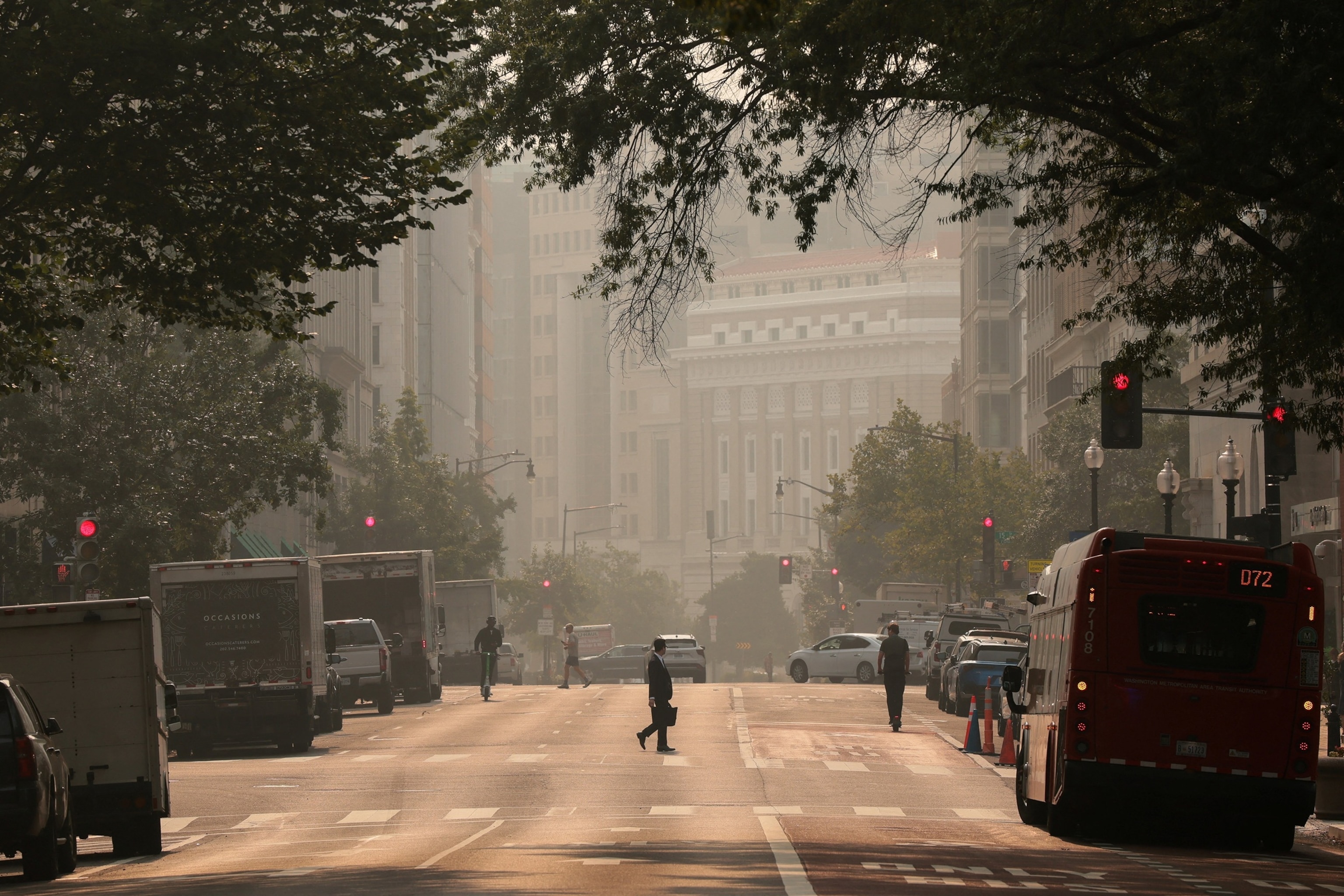A person crosses the street as smoke from Canadian wildfires blankets Washington, July 17, 2026.Kylie Cooper/Reuters