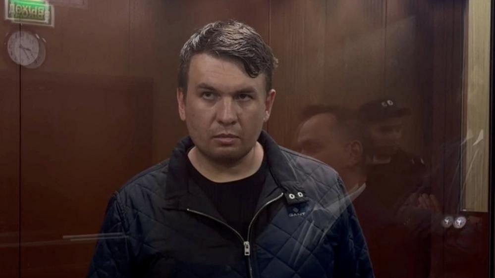 Image caption,Remeslo appeared in a Moscow court late on Friday inside a defendant's cage