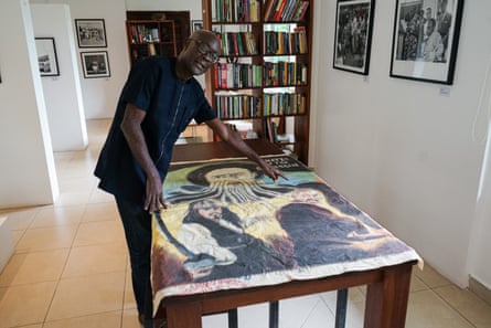 Joseph Oduro-Frimpong displays a hand-painted film poster for the film Pirates of the Caribbean from his collection.Photograph: Carlos Mureithi/The Guardian