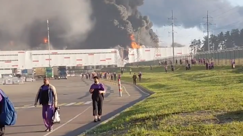 Image caption,Footage showed flames engulfing a large warehouse as workers evacuate