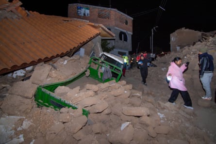 People walk among the debris of homes that collapsed after the earthquake struck.Photograph: Javier Ninanya/AP