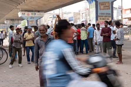 Daily-wage labourers wait at Badshahpur market, Gurgaon, to be picked by contractors for construction work.Photograph: Smita Sharma/The Guardian