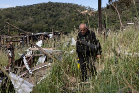 Nilton Tubino walks past the remains of buildings in Vila Cururu.Photograph: João Laet/The Guardian
