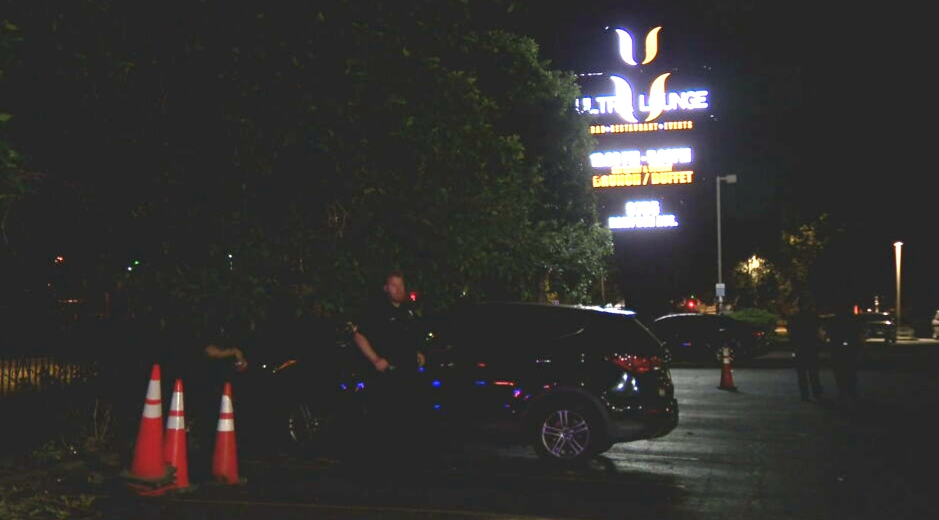 A police officer stands outside the Ultra Lounge in Denver, Colo., July 20, 2026, following a shooting in the nightclub's parking lot that left one person dead and eight others injured.KMGH
