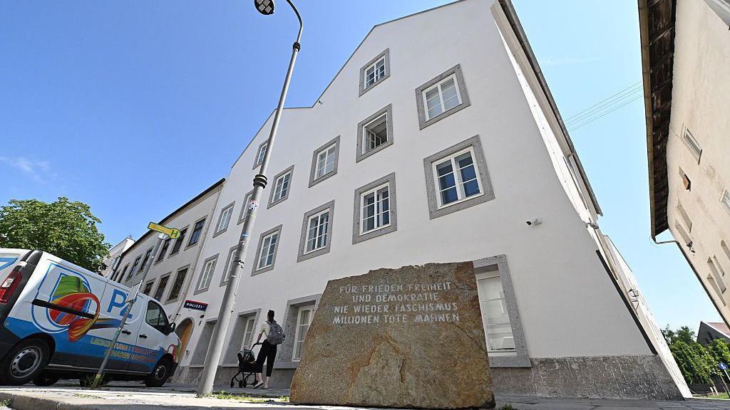 Image caption,A memorial stone outside the building reads "For Peace, Freedom and Democracy - Never Again Fascism - Millions of Dead Warn"