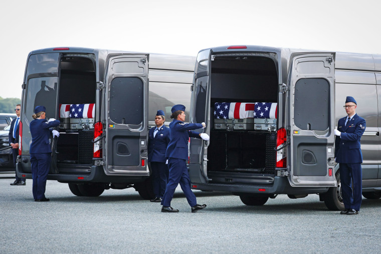 Flag-draped transfer cases are loaded into vehicles Wednesday at Dover Air Force Base.Kevin Dietsch / Getty Images