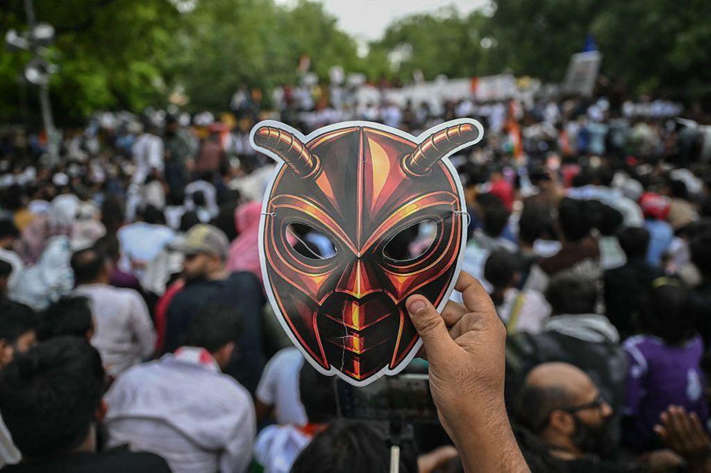 Image caption,A protester hurls a tear gas canister back at police during a CJP march in Delhi